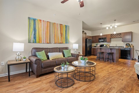 a living room and kitchen with a couch and tables